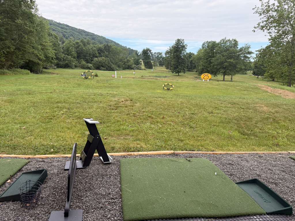 Single-level outdoor driving range tee bays